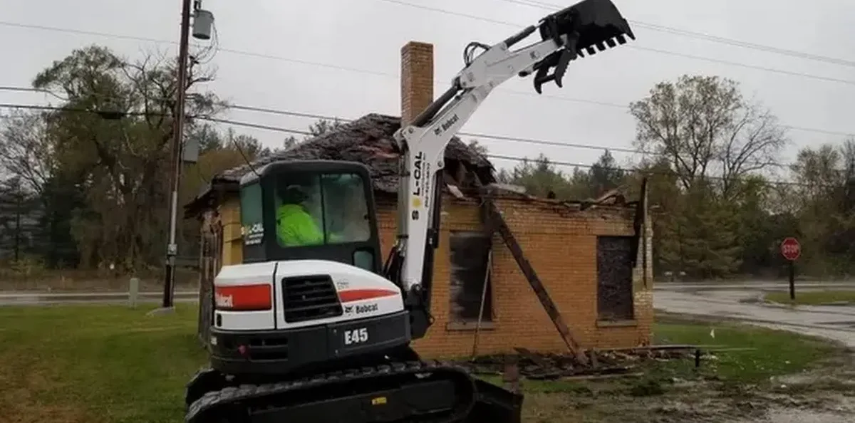Sol-Cal Construction excavator removing a damaged building at a real demolition project