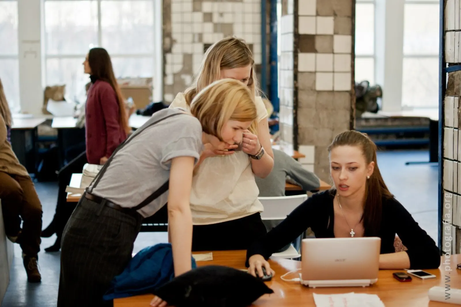 Coworking team collaborating around a laptop in a shared office