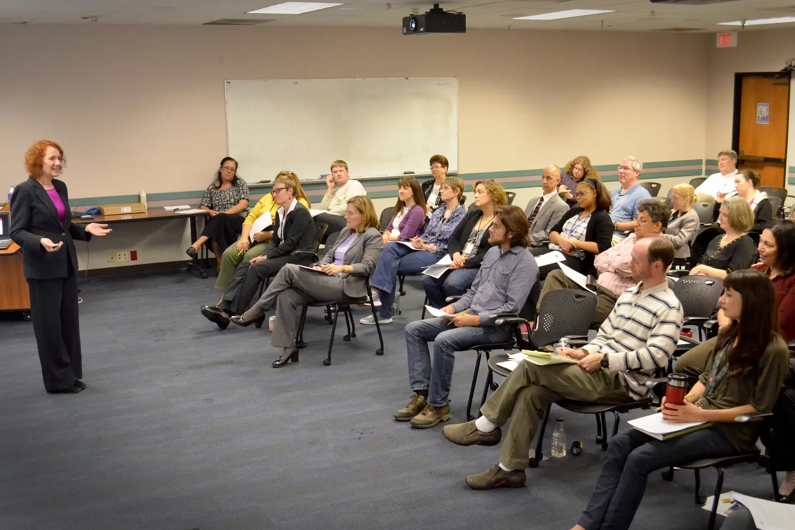 Facilitator leading an in-person working session with a seated group