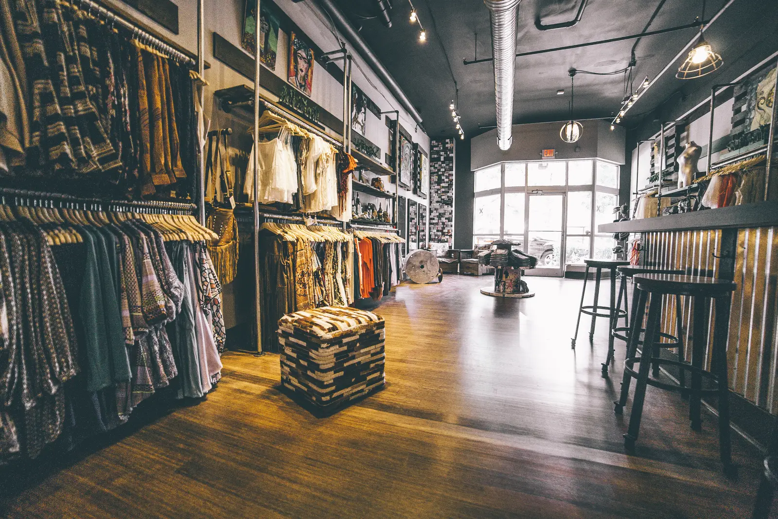 Real clothing boutique interior with garments arranged on racks and shelves