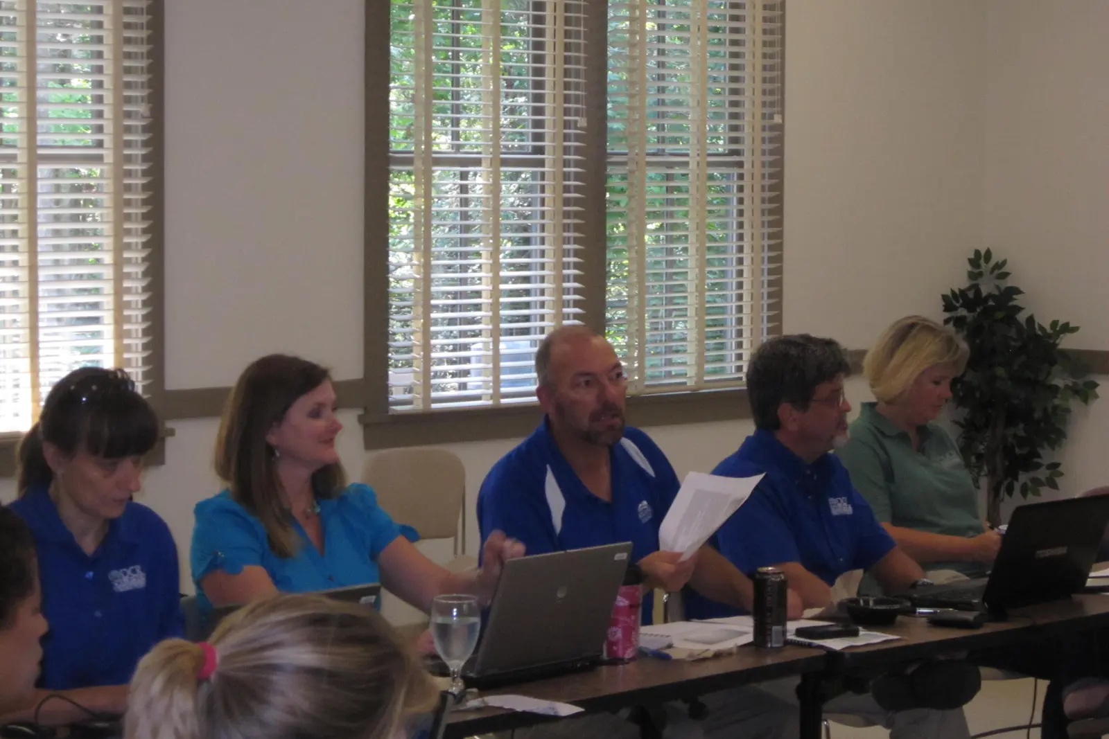 Marketing team holding a working session around laptops and campaign material