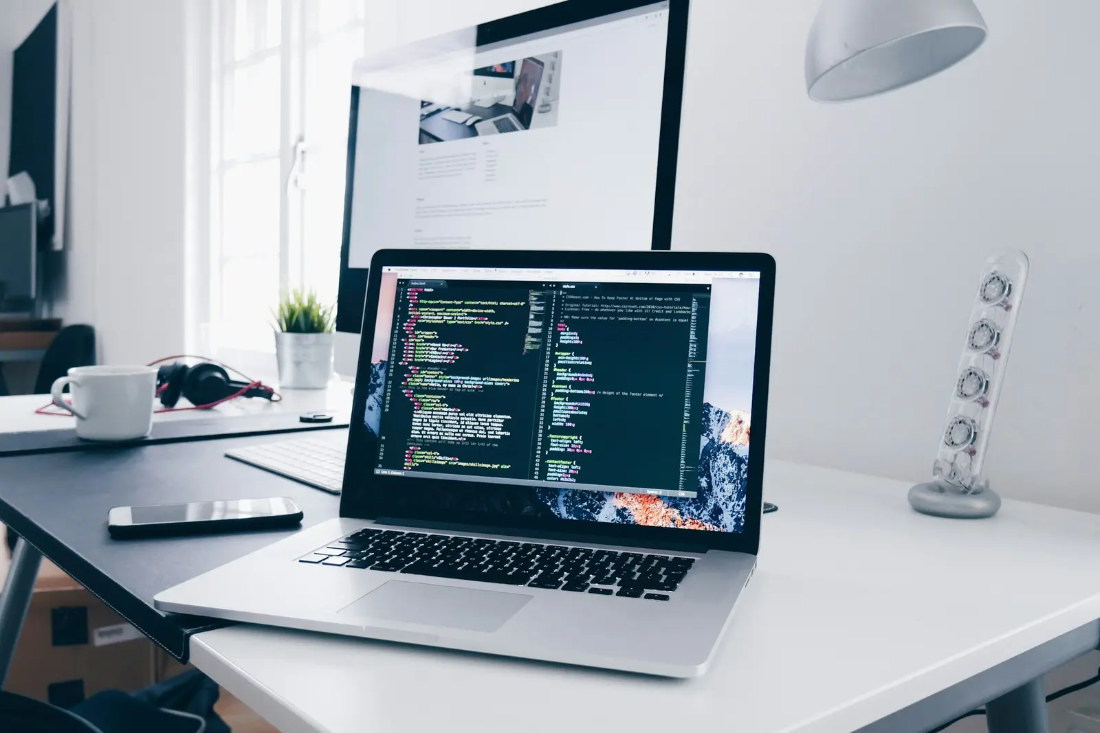 Laptop displaying working source code on a developer desk