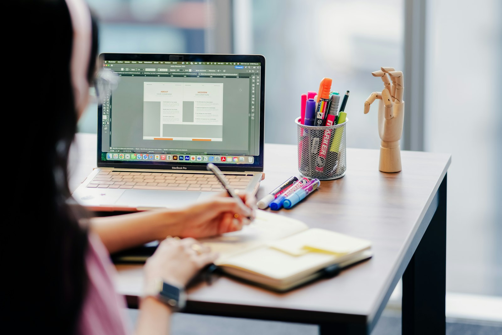 Person planning a website at a desk with a laptop and notebook