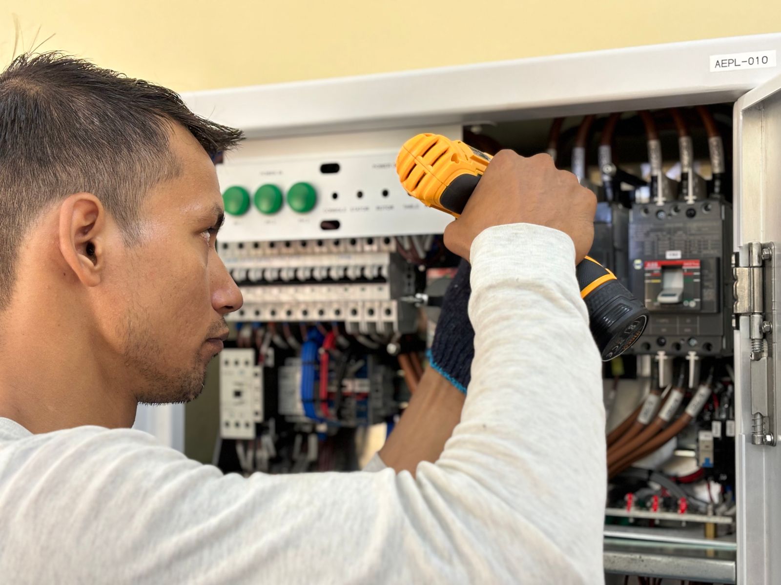 Electrical professional working at a control panel