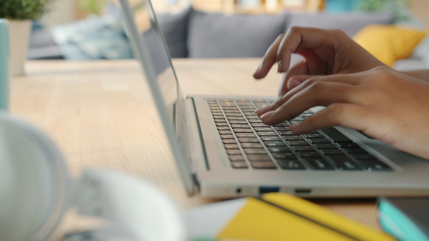 Hands typing at a laptop